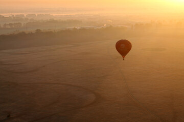Alone hot air balloon during sunrise in the rays of the sun