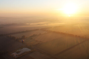 Balloon on the background of the sun during sunrise.