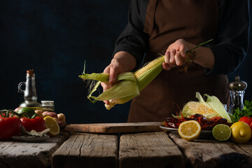 The chef prepares crayfish with corn and vegetables. The photo shows the cooking process. The chef...