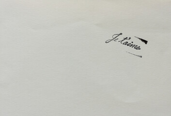 rubber stamp impression (in black ink) with the words je t'aime on paper