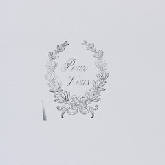 rubber stamp impression of a decorative floral motif with the message in french of pour vous (for...