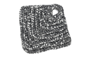 Pot holder for hot dishes knitted of thick black and white cotton yarn.