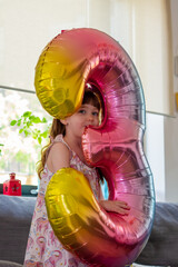 A Cute Baby Girl Holding A Number Three Balloon