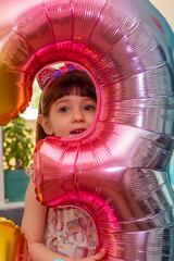 A Cute Baby Girl Holding A Number Three Balloon