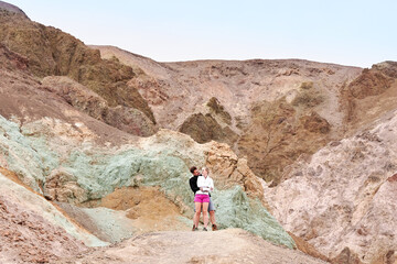 Fototapeta premium A family with a teenage girl is hiking Dante’s View trail in Death Valley National Park in California, USA during their road trip from Las Vegas to San Francisco in March 2021 during COVID-19 pandemic