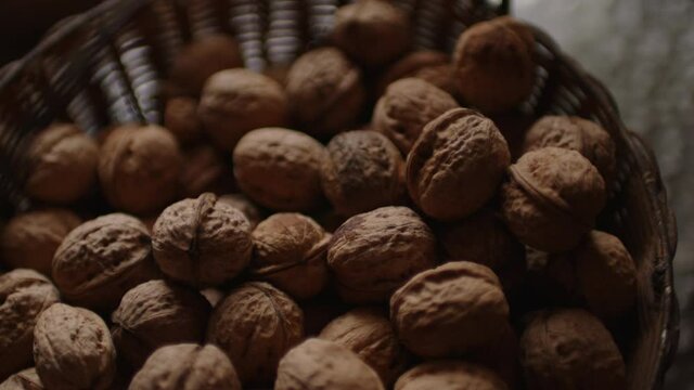 Close up of walnuts crop in basket. Pile of nuts in shell in bowl.