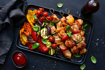 Chicken skewers kebab with grilled vegetables. Top view with copy space.