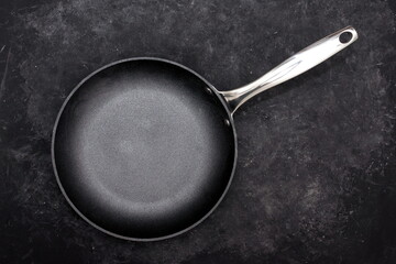 Empty Frying Pan, Top View. Cast Iron Fry Pan on Black Background. New And Clean Frying Pan On Black Table Overhead View.