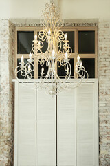 Background of a room with a chandelier and a window covered with a screen, white brick walls