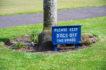 Please keep dogs off the grass sign