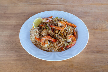 A top-down view of Thai food with a wood background. Bamboo shoots, Glass noodles, Carrot, Oyster sauce, Rice, shrimp, Cabbage, onions, strong basil, 