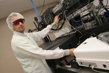 Scientist in a laser technology research laboratory working on a high-performance laser and...