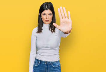 Beautiful brunette woman wearing casual clothes doing stop sing with palm of the hand. warning expression with negative and serious gesture on the face.