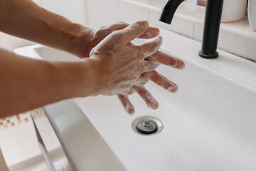 Washing hands with white foam in the toilet. Concept of cleaning and protection.