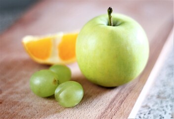 green apple orange and grape on a table juicy fruits
