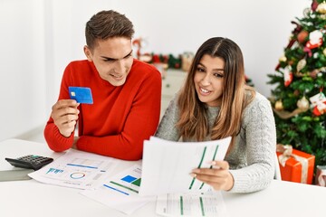 Fototapeta premium Young couple controlling family economy sitting on the table at home.