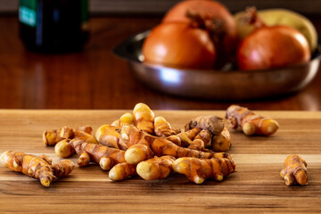Raw fresh turmeric roots on a wooden table