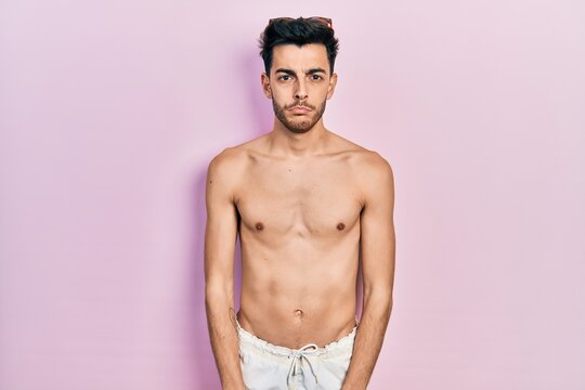 Young hispanic man wearing swimwear shirtless depressed and worry for distress, crying angry and afraid. sad expression.