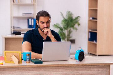 Young male employee working at workplace