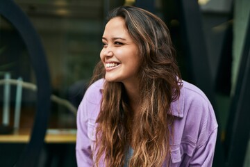 Young hispanic woman smiling happy standing at the city.