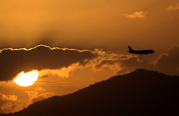 Atardecer con el sol ocultándose mientras un avión va en vuelo en Panamá