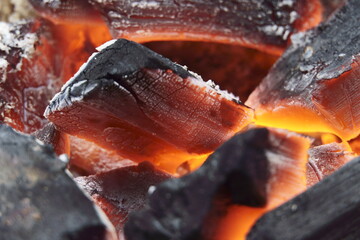 Macro closeup of red-hot coal on the barbecue. Flames of fire, coal, ember and smoke.
