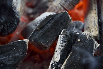 Macro closeup of red-hot coal on the barbecue. Flames of fire, coal, ember and smoke.