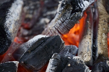 Macro closeup of red-hot coal on the barbecue. Flames of fire, coal, ember and smoke.