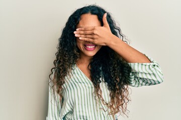 Young latin woman wearing casual clothes smiling and laughing with hand on face covering eyes for surprise. blind concept.