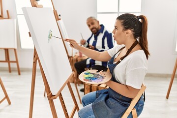 Young artist woman at art studio scared and amazed with open mouth for surprise, disbelief face