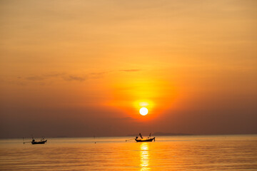 A boat floating in the sea for fishing in the sunset.