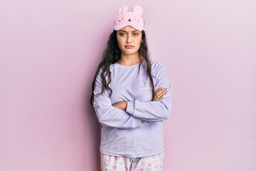 Beautiful middle eastern woman wearing sleep mask and pajama skeptic and nervous, disapproving expression on face with crossed arms. negative person.