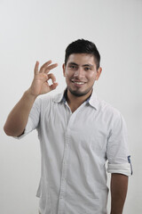Hombre latino sonriendo haciendo gesto de aprobación okey