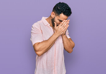 Hispanic man with beard wearing casual shirt with sad expression covering face with hands while crying. depression concept.