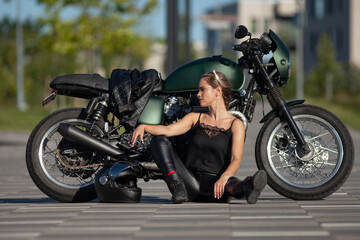 Plakat Portrait of young woman on a black motorcycle