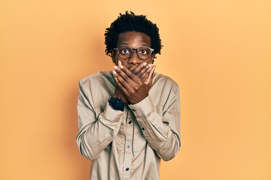 Young african american man wearing casual clothes and glasses shocked covering mouth with hands for mistake. secret concept.