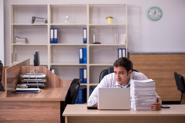 Young male employee unhappy with excessive work in the office