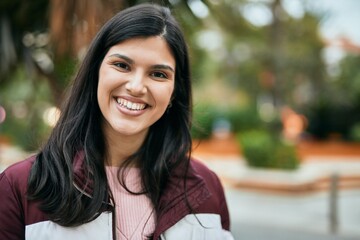 Young hispanic girl smiling happy standing at the park.