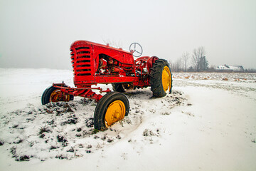 old red farm tractor on the snow © Bob Orsillo
