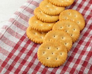 Cracker cookies with tablecloth on white wooden table background.