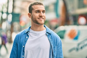 Young caucasian man smiling happy standing at the city.