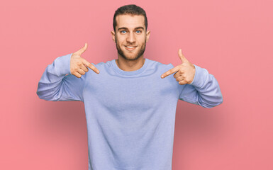 Young caucasian man wearing casual clothes looking confident with smile on face, pointing oneself...