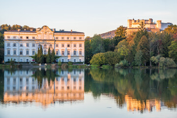 Fototapeta na wymiar Beautiful sunset colors in Leopoldskroner Weiher Lake with Leopoldskron Palace and Hohensalzburg Fortress in the background - Salzburg, Austria 