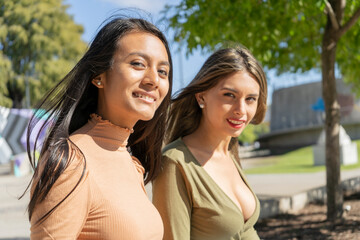 Two young friends chatting relaxed in a concrete square. Friendship concept, casual photography.