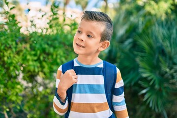 dorable caucasian student boy smiling happy standing at the park.