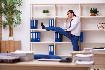 Young male employee doing sport exercises during break