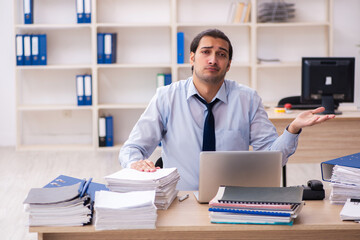 Young male employee and too much work in the office