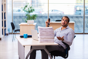 Young male employee unhappy with excessive work in the office