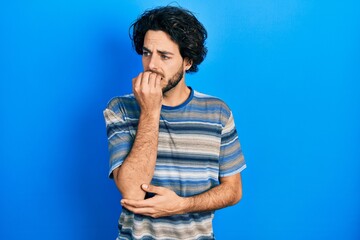 Fototapeta na wymiar Handsome hispanic man wearing casual clothes over pink background looking stressed and nervous with hands on mouth biting nails. anxiety problem.