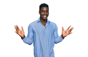 Handsome business black man wearing casual striped t shirt celebrating victory with happy smile and winner expression with raised hands